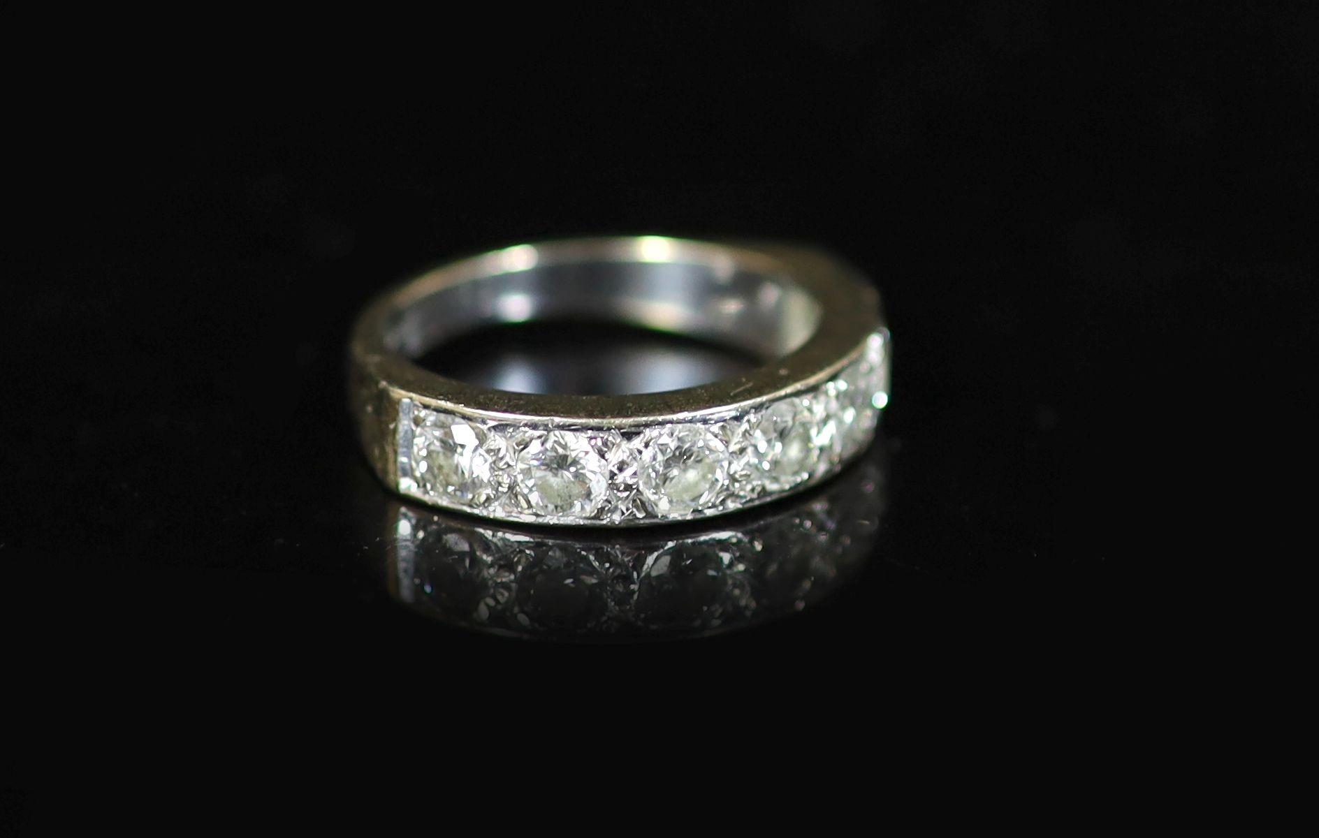 A modern white gold and channel set seven stone diamond half hoop ring